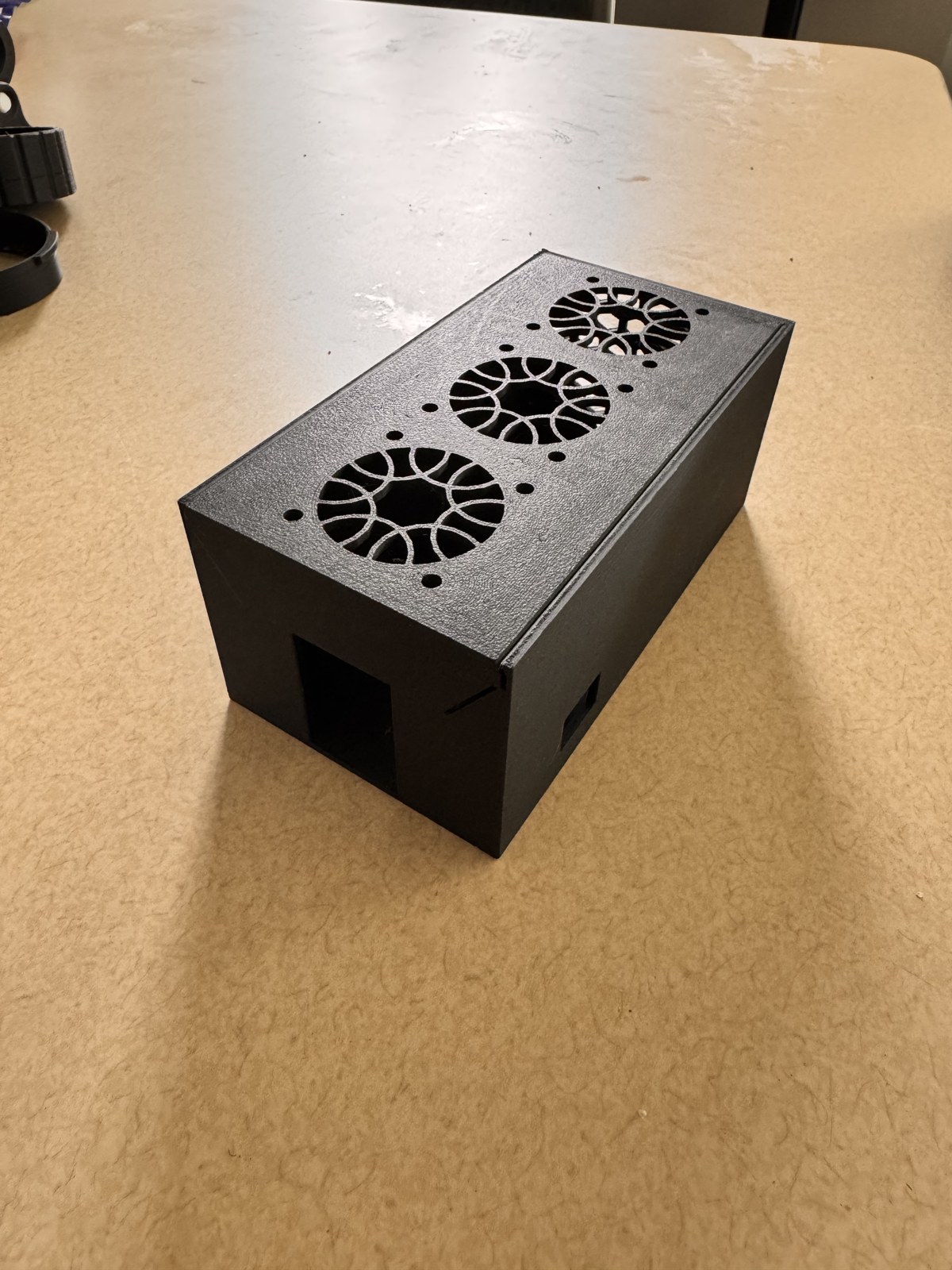 Three quarter view of the assembled cooling box from the opposite side showing the same USB-C cutout and the open end where the SSD slides in
